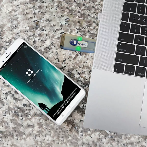 Secure USB Drive Evikey NFC Pro connected to a laptop with a green LED indicating data transfer activity.