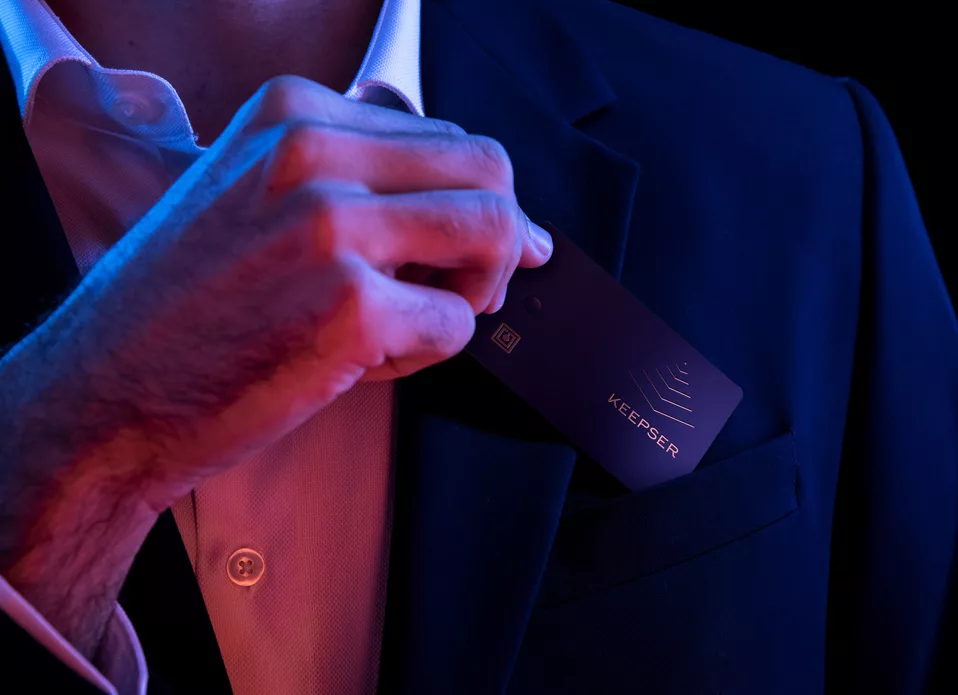 Man in business attire placing a Keepser NFC card in his pocket, symbolizing secure and professional data management solutions.